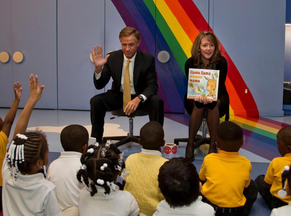 Bill and Crissy Haslam reading a story book to children.