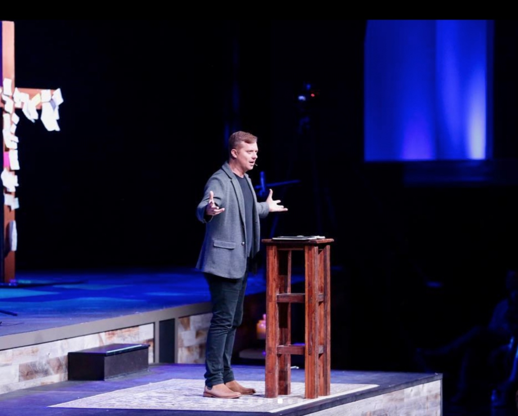Pastor of Church of the City, Darren Whitehead preaching to his congregation